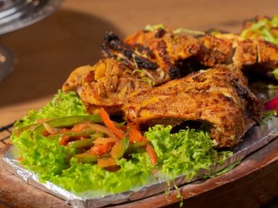 Chicken tikka with salad on a wooden board