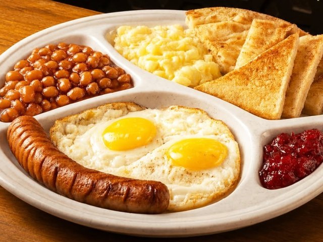 Fried eggs, sausage, beans and toast on a breakfast plate